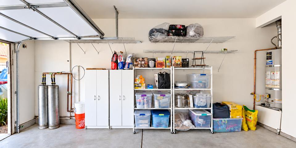 Garage storage wall after organizing, with supplies grouped in cabinets, shelves and bins