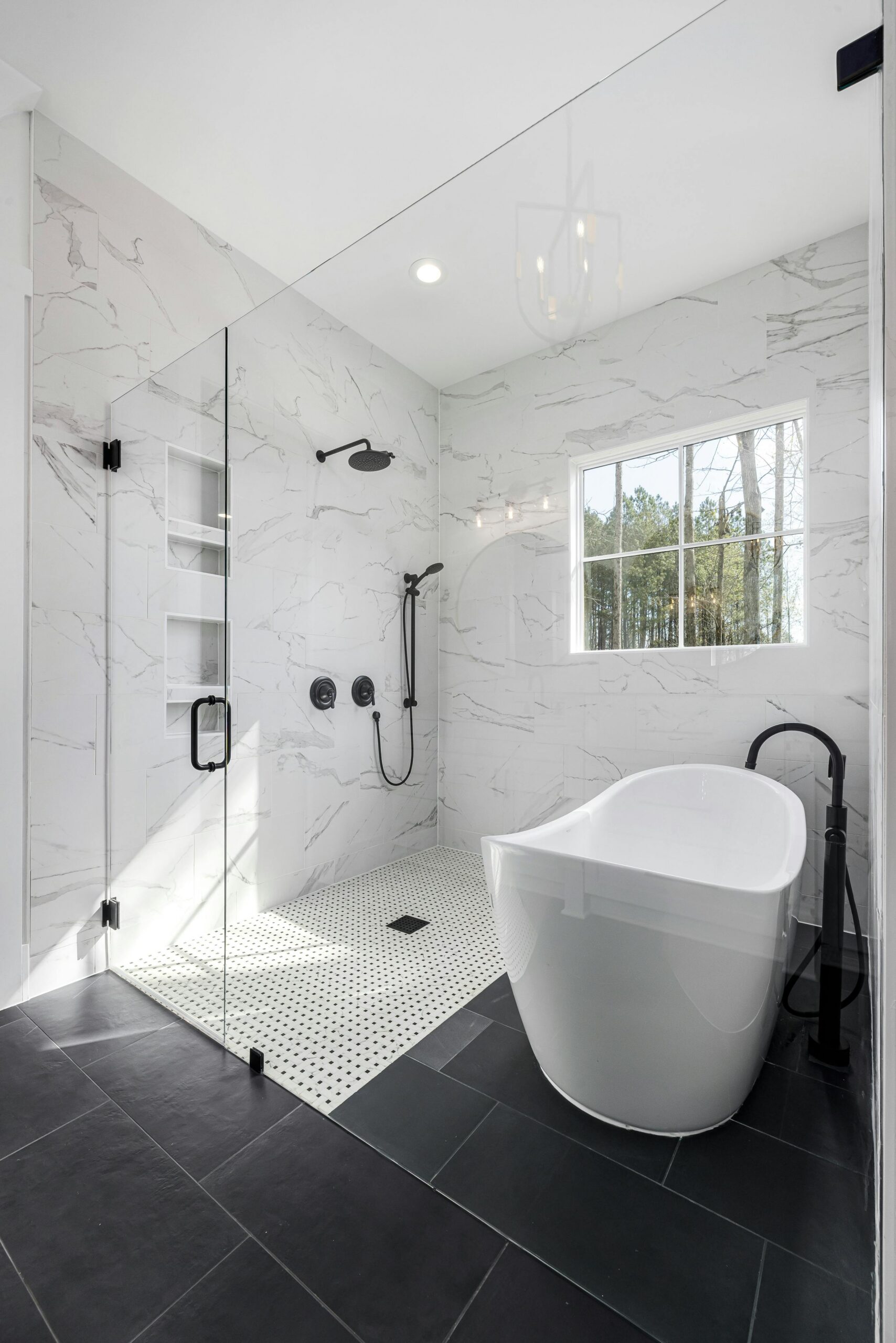 Sleek white bathroom with freestanding tub, glass shower, and natural lighting.